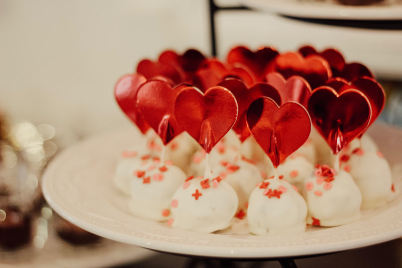 white chocolate covered red velvet truffles with heart skewers