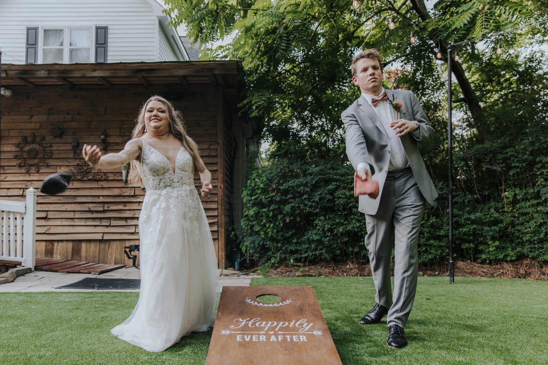 bride and groom playing cornhole