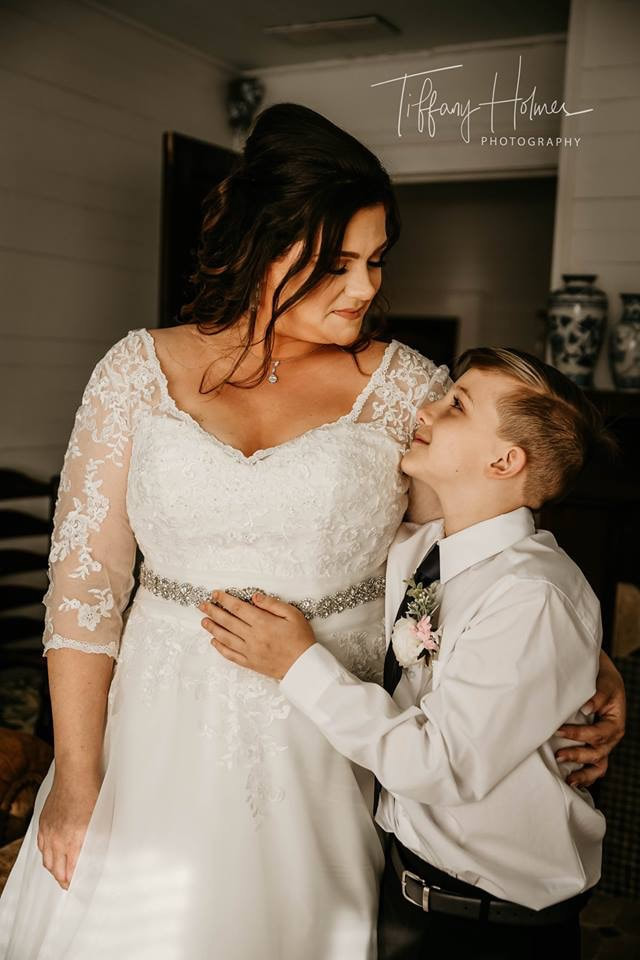 Bride sharing side-hug with young son