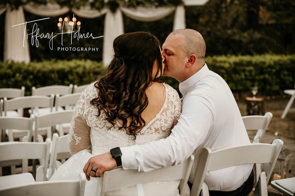 Bride and groom kissing in ceremony chairs