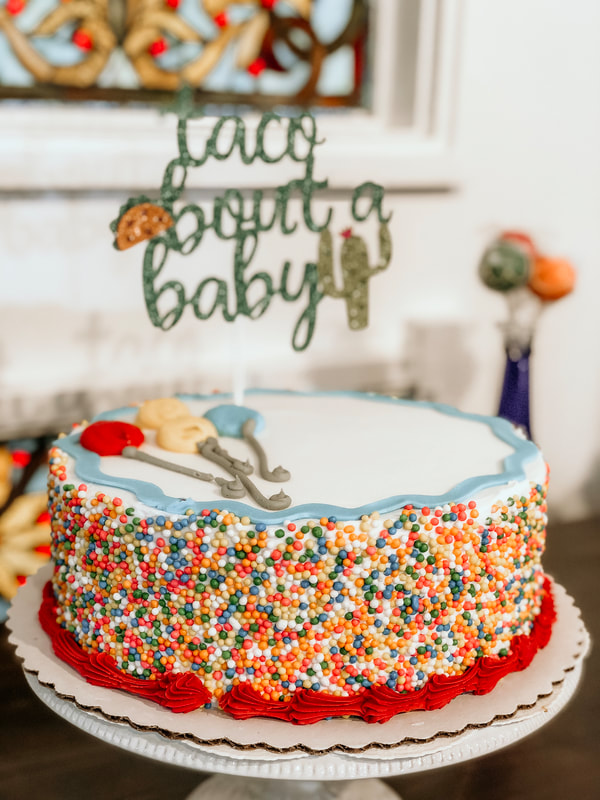 sprinkle covered cake with 'taco bout a baby' cake topper