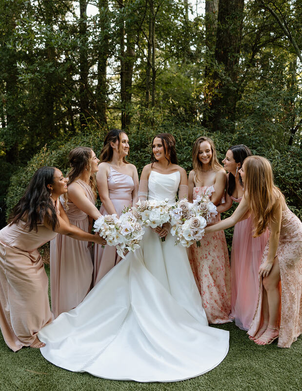 bride standing with bridesmaids in mismatched blush dresses