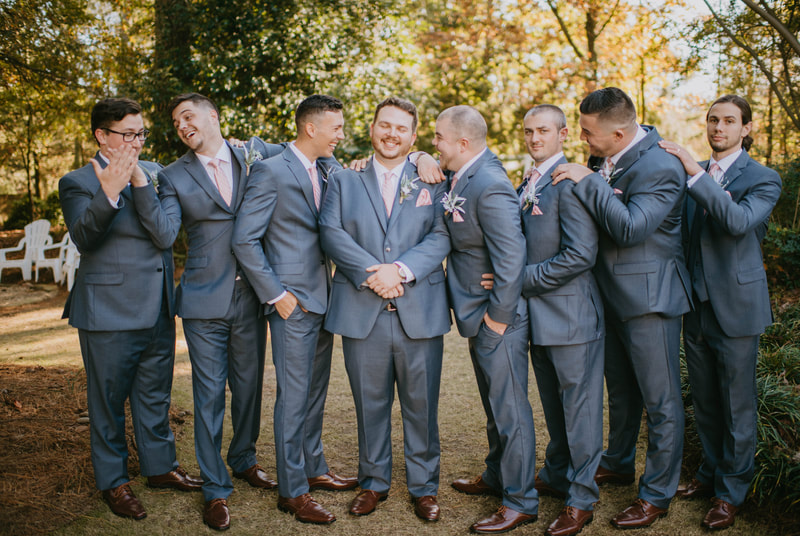 groomsmen laughing during portraits in Four Oaks' gardens