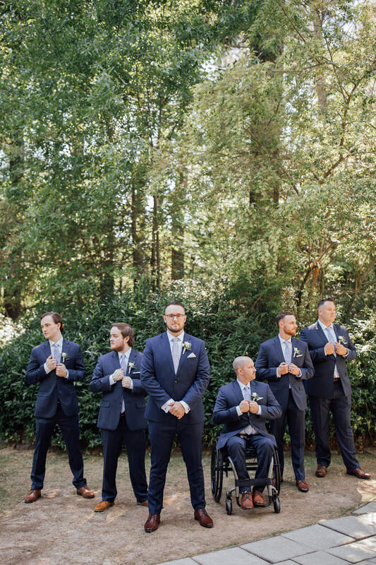 groomsmen posing in blue suits in garden