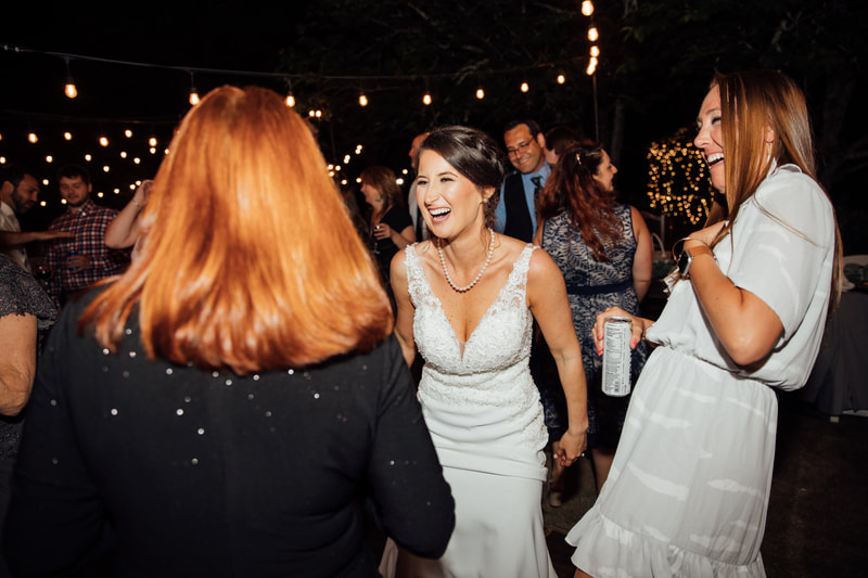 bride dancing with guests during outdoor reception