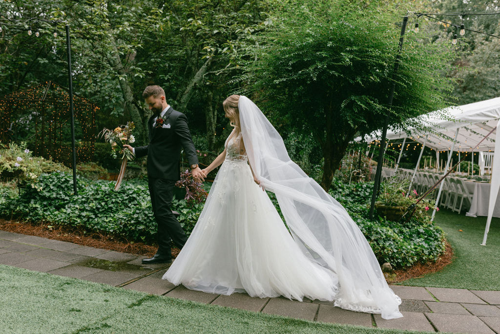 Bride & groom walking through gardens