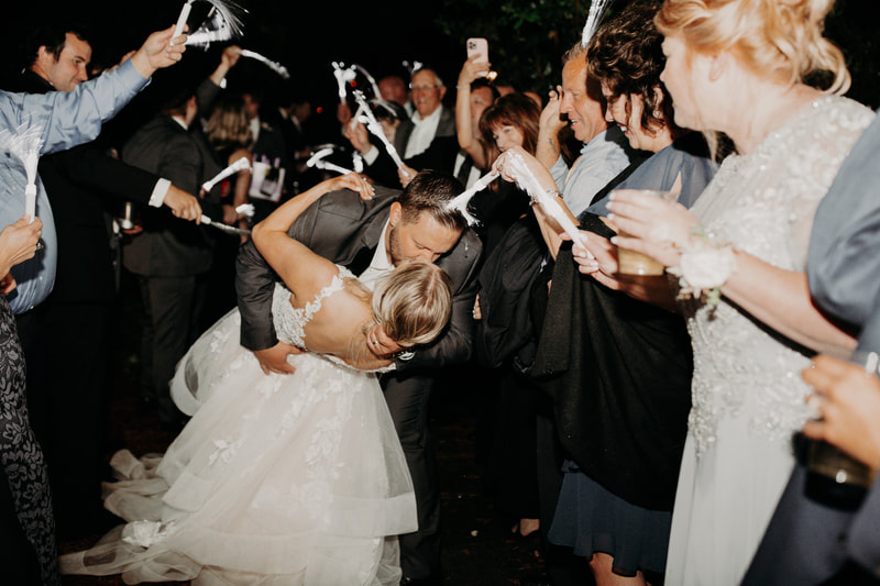 groom dips bride for kiss during grand exit