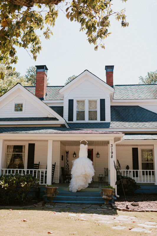 white mermaid dress hanging on farmhouse front porch