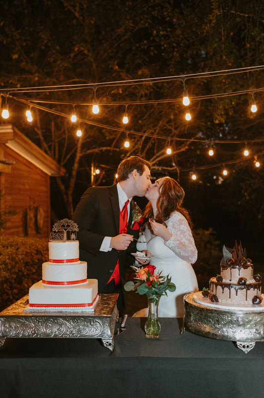 newlyweds kissing by wedding cakes 