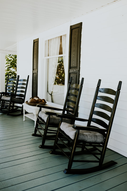 black rocking chairs on farmhouse front porch