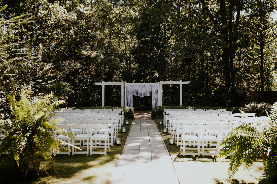 outdoor ceremony area with boho wedding altar with macramé