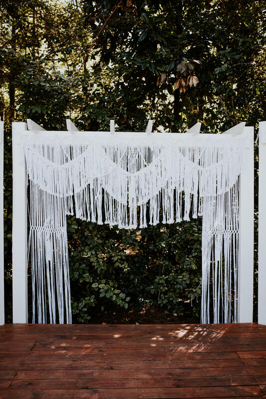 white macramé on white outdoor wedding altar