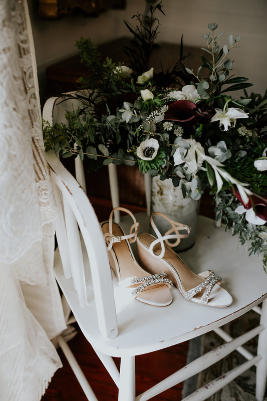 bridal shoes and bouquet on white chair