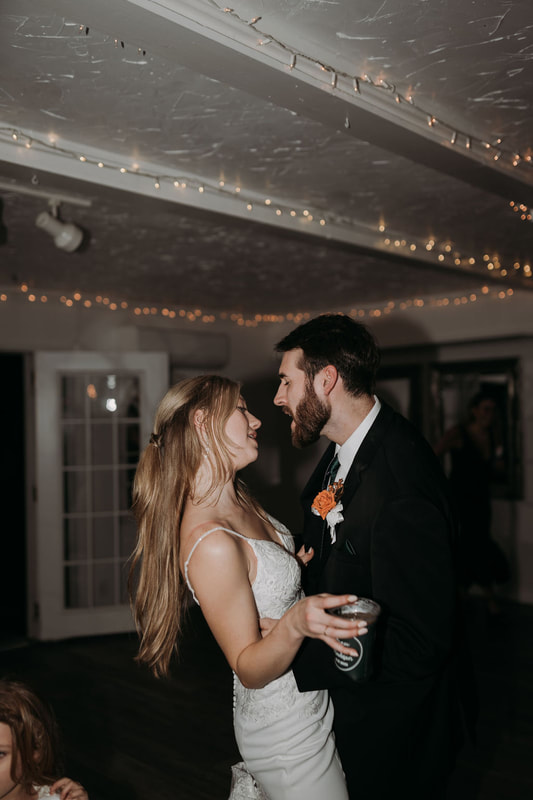 bride and groom dance alone in farmhouse ballroom