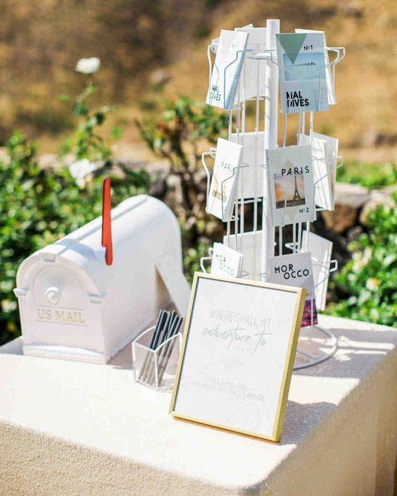 white guest book table with modern post cards and white mail box