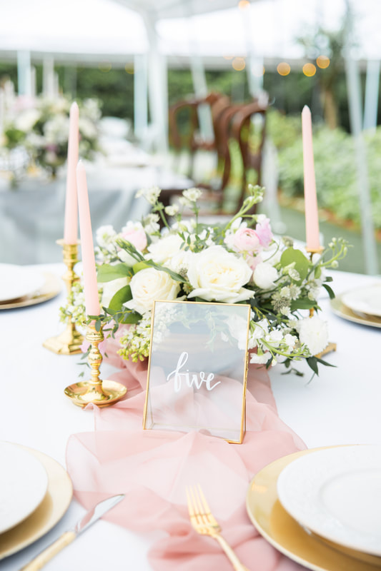shades of pink and white floral arrangement with gold table decor