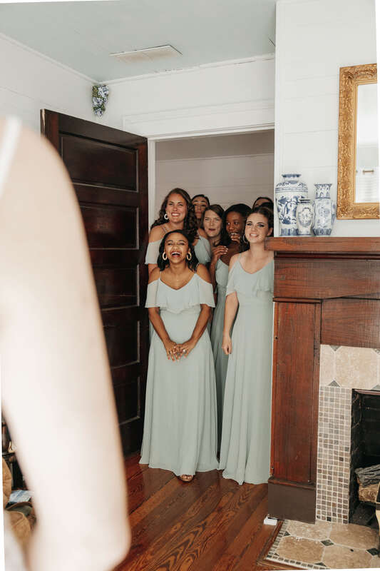 bridesmaids reacting to bride in her dress