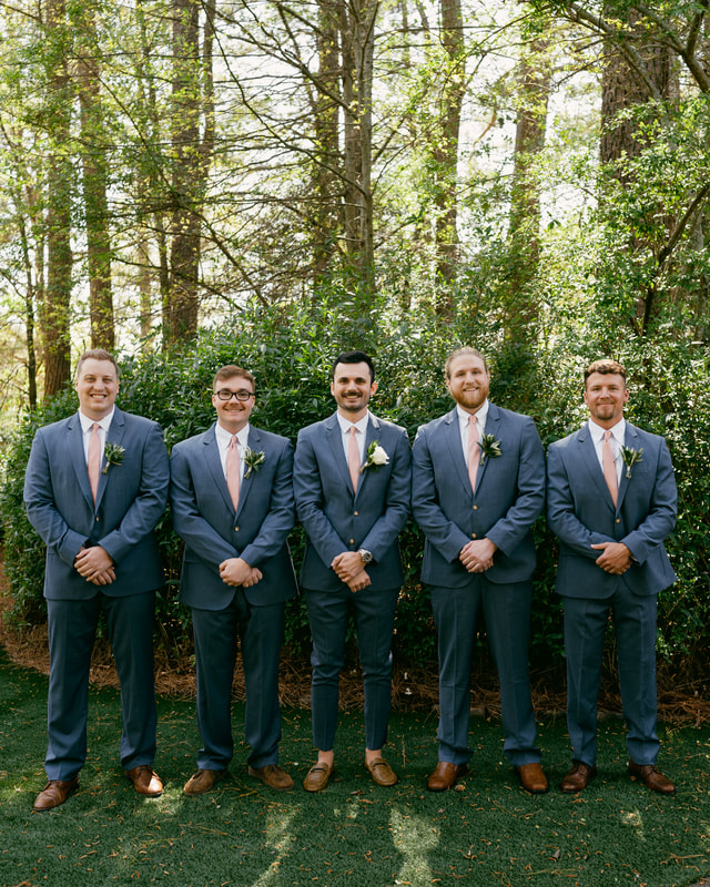 groom and groomsmen in dusty blue suits and blush ties