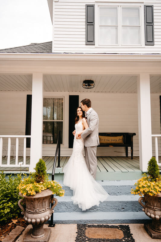 bride and groom on white farmhouse steps