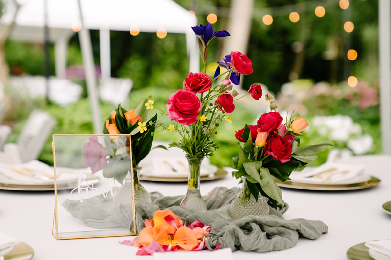 Budvases and cheesecloth runners with colorful flowers