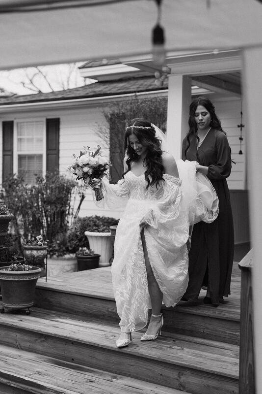 black and white photo of bride walking down farmhouse steps