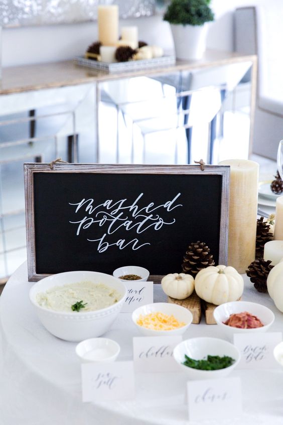 mashed potato bar with potatoes, toppings, chalkboard signs, and mini white pumpkins and pine cones for decoration