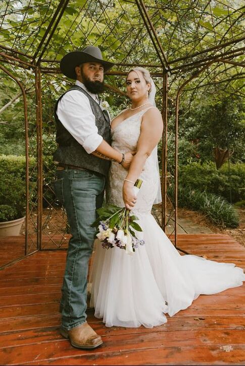 groom in cowboy hat posing with bride