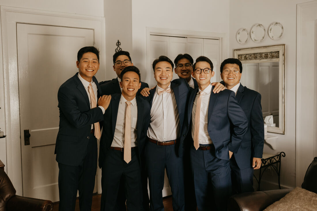 groom and groomsmen in navy suits with blush ties
