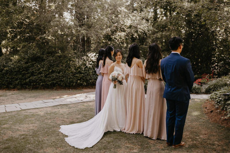 bride in gardens with blush and blue bridal party