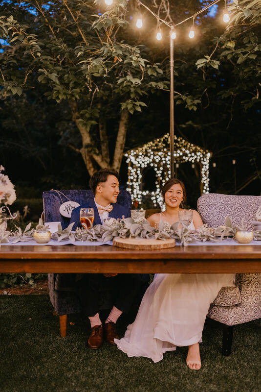 bride and groom at head table under garden lights