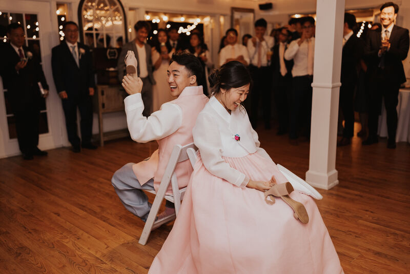 bride and groom in hanbok playing shoe game