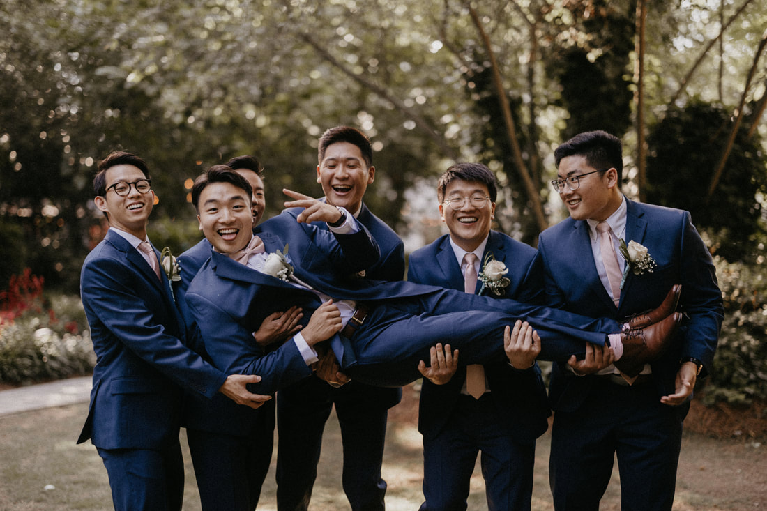 groomsmen holding up groom