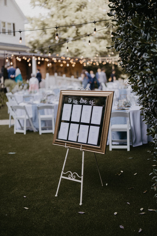 garden reception with seating chart on gold mirror