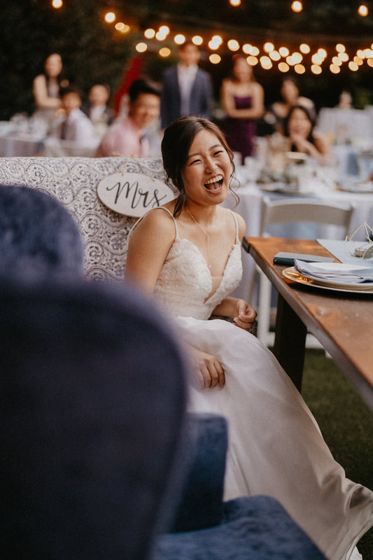bride laughing at head table