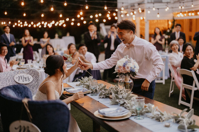 groom giving rose to bride during reception