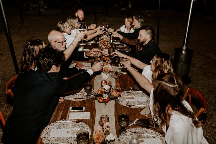 guests clinking glasses during night outdoor wedding reception