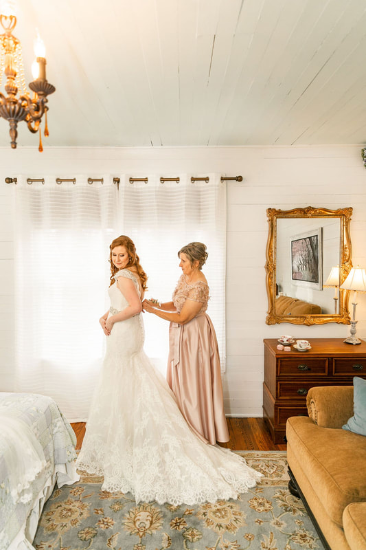 mother buttoning bride's dress in farmhouse getting ready suite