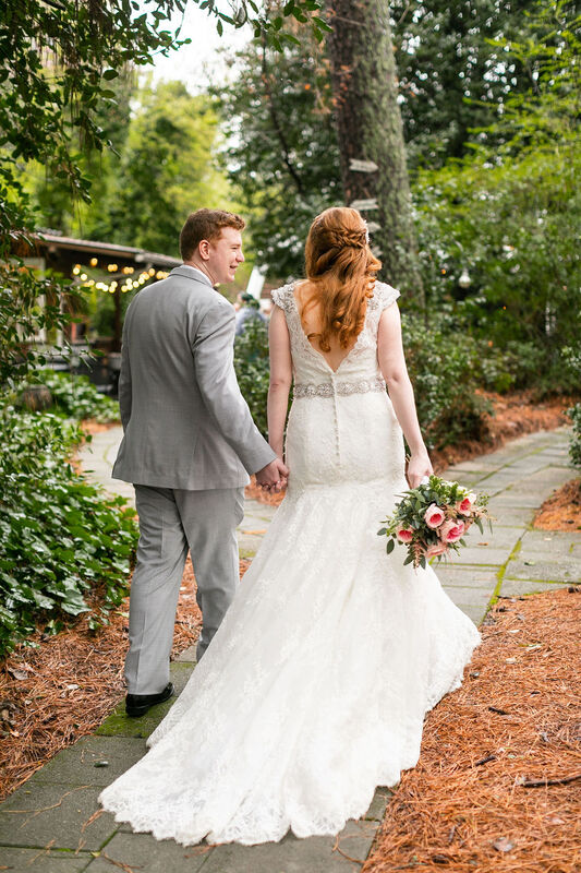 newlyweds walking through garden venue path