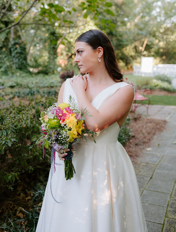 bride with wildflower bouquet posing along path