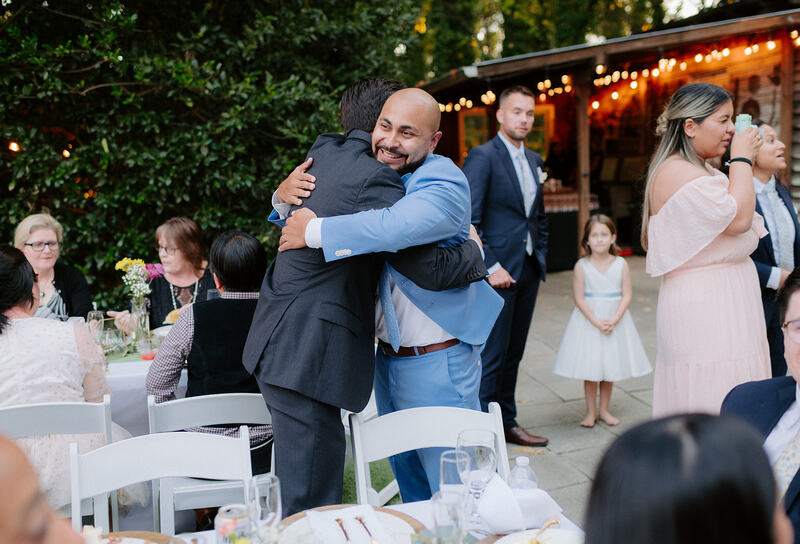 groom hugging gests during reception