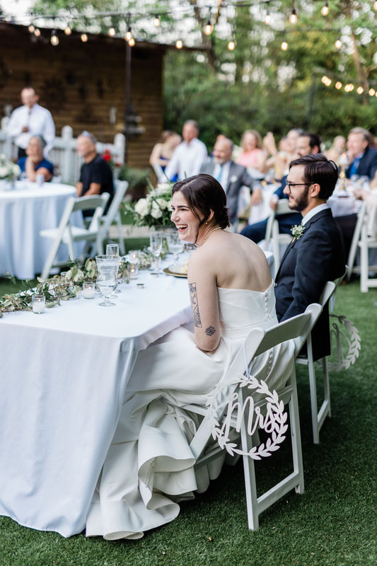 bride and groom laughing at sweetheart table