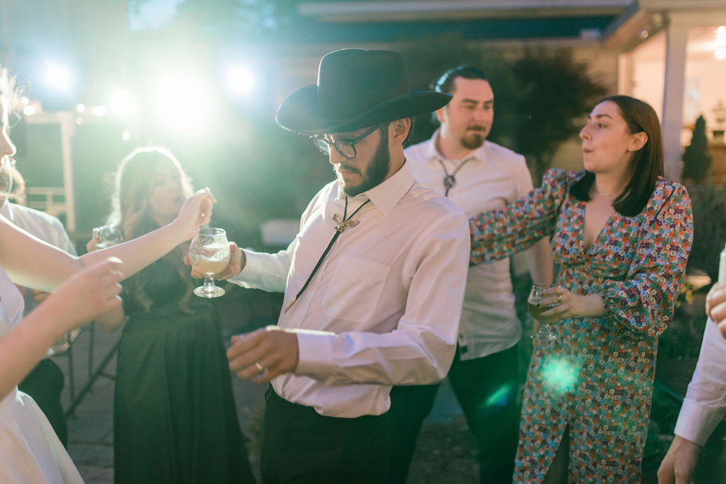 groom in cowboy hat dancing with guests