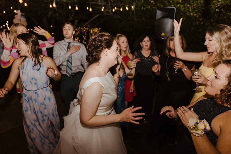 bride dancing with guests at outdoor reception