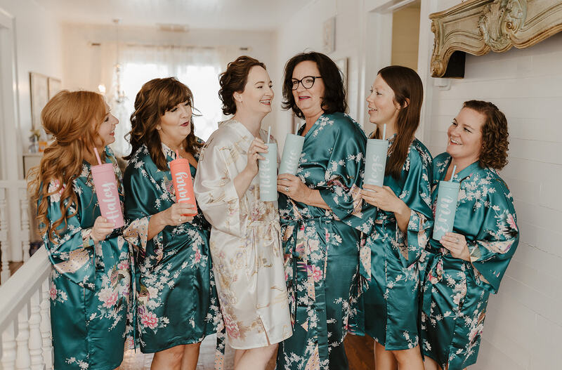 bride and bridesmaids in floral white and teal robes