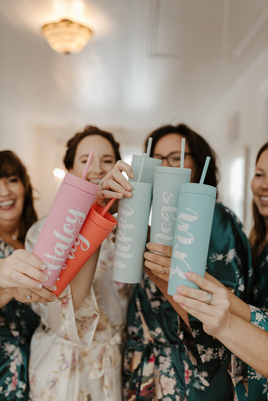 bridesmaids holding out pastel personalized water bottles