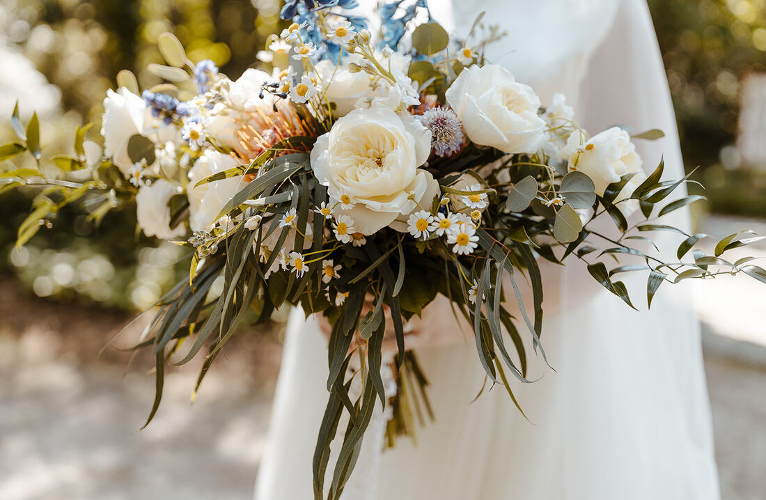 large bridal bouquet with ranunculus, wild flowers, and greenery