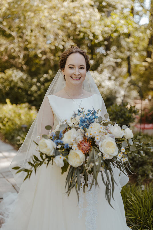 bride with bouquet of white roses and bright flowers