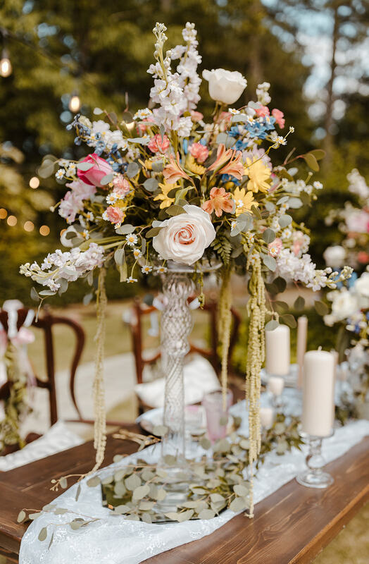 floral centerpiece on tall glass stand