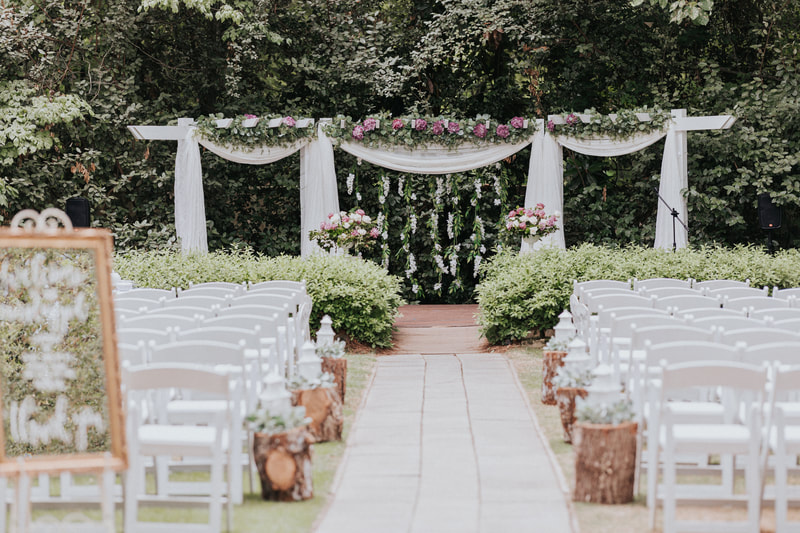 floral outdoor altar with pink and white flowers and greenery
