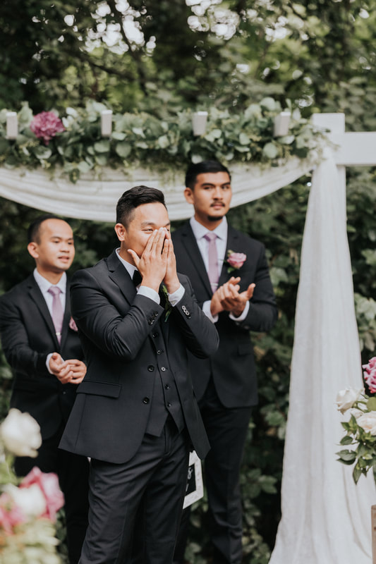 groom at altar reacting to bride